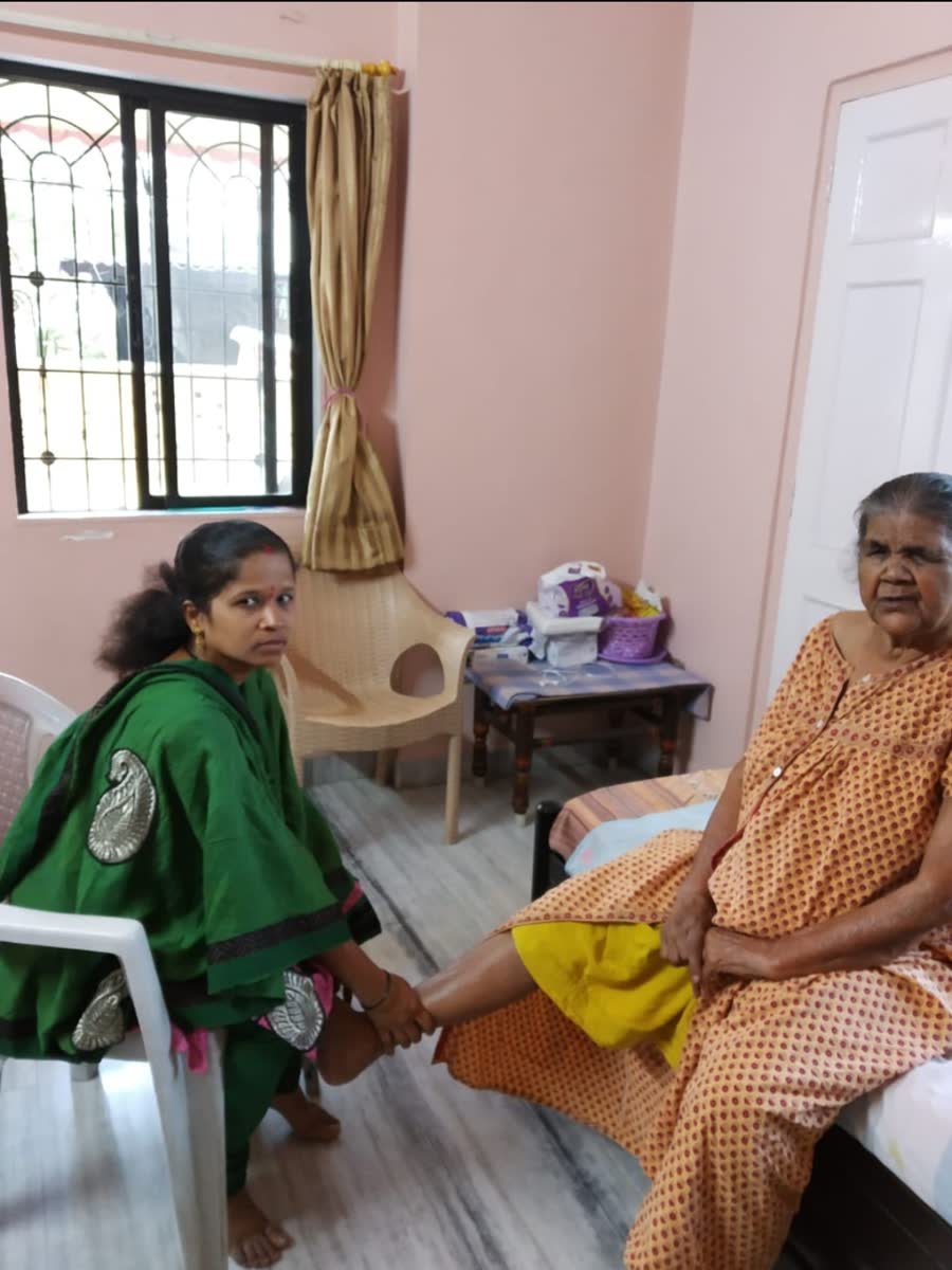 Caregiver attentively supporting a senior reclining in an armchair at home