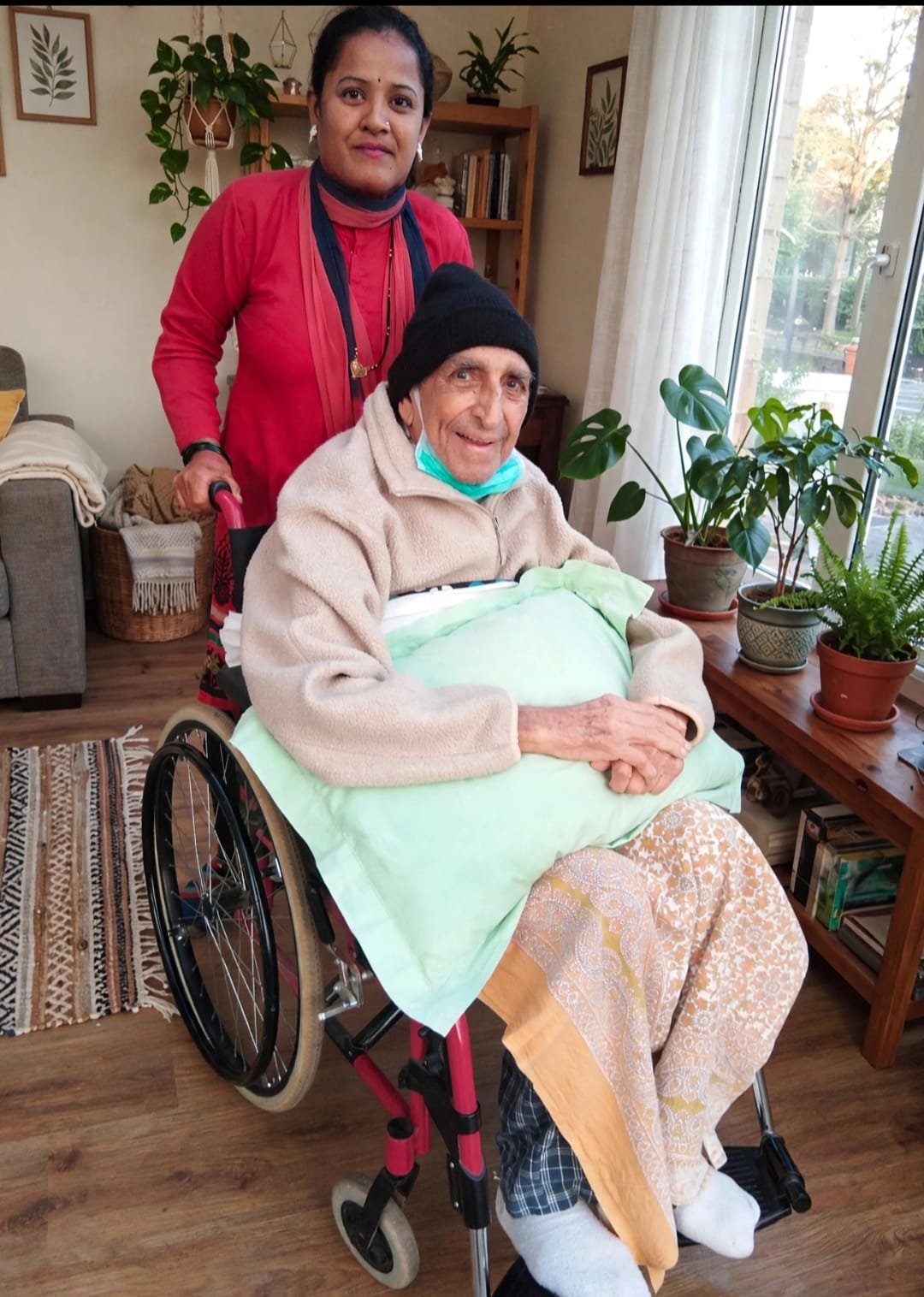 Professional home-care nurse compassionately assisting an elderly patient at home in Mumbai